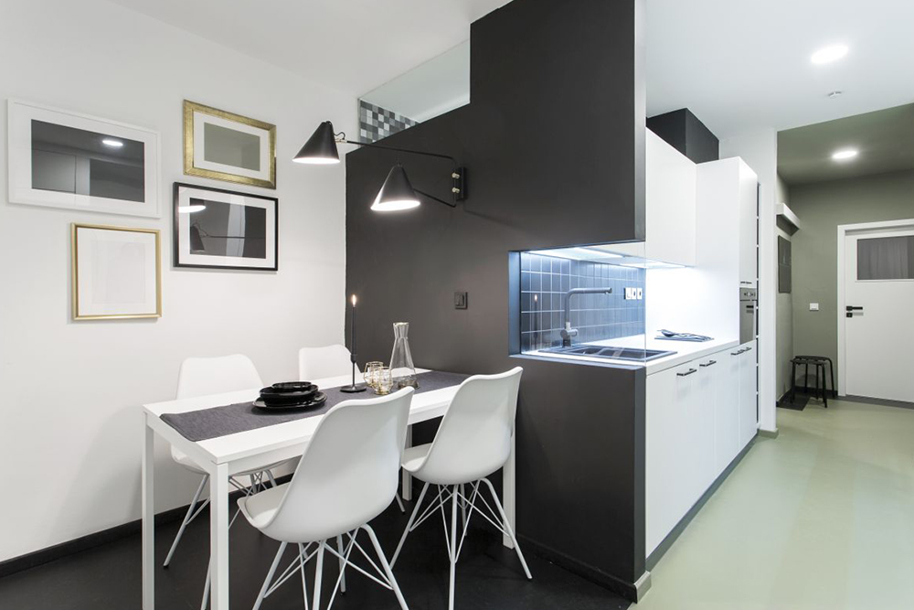Moderní kuchyně s jídlením koutem v kombinaci bílé a černé barvy