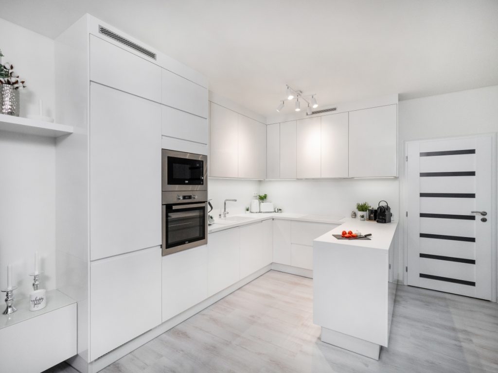 Bílá kuchyně do U v minimalistickém stylu.