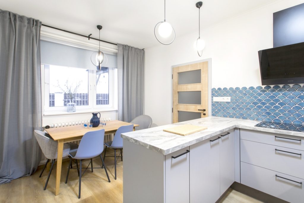 Romantická kuchyně do bytu v bílé barvě s kachličkami v modré barvě.